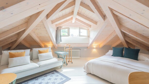 A cozy attic bedroom with a loft bed, a sofa, and a small table. - Villa Olga With Private Pool by Rent all Como (Tremezzina)