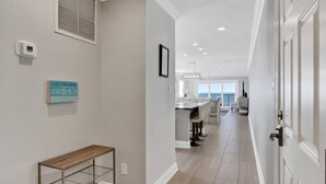 Ein modernes Interieur mit einem Flur, der in einen Essbereich und eine Küche führt.