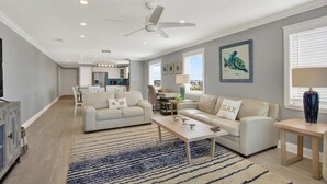 Ein geräumiges Wohnzimmer mit zwei Sofas, einem Couchtisch und einem Deckenventilator.