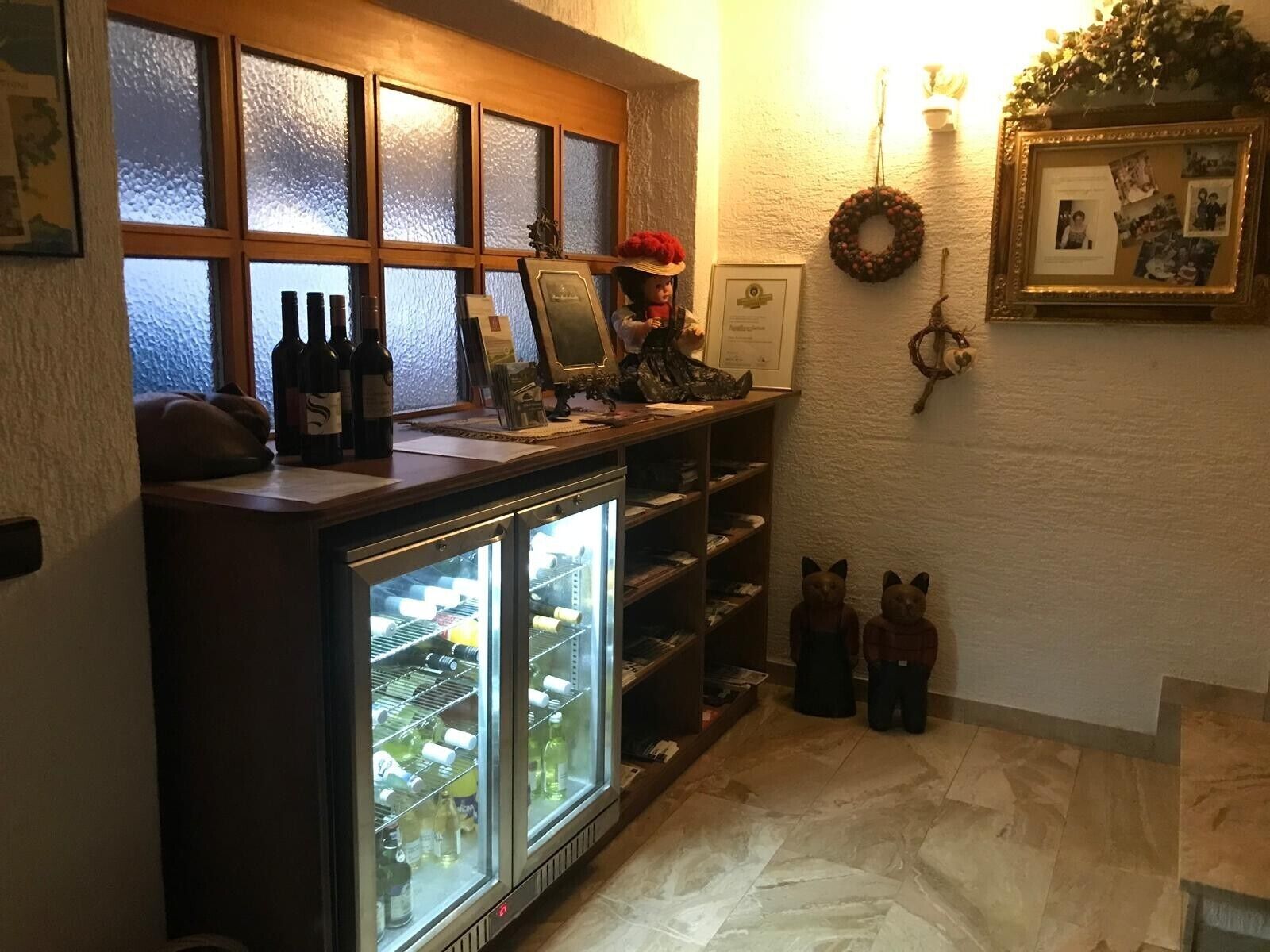 Un'area bar con un frigorifero, scaffali e una vetrina.