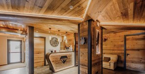 A wooden interior with a reception desk, a clock, and a sofa. - Hotiday Sauze Centro (Sauze d'Oulx)
