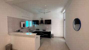 A modern kitchen with a central island, a built-in oven, and a microwave.