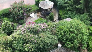 A garden with a gazebo, a paved pathway, and various shrubs. - Apartment 'Schwalbennest' with Mountain View, Private Balcony and Wi-Fi (Sasbachwalden)
