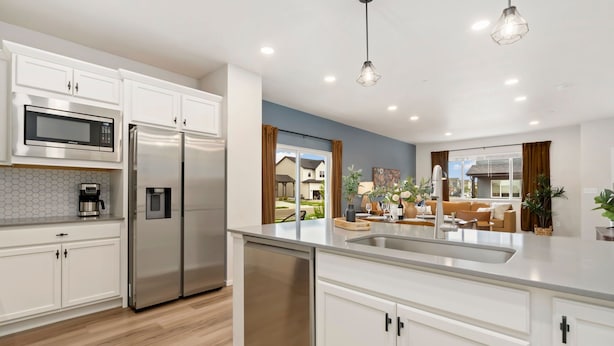 Una cocina moderna con electrodomésticos de acero inoxidable, lavavajillas y una isla grande con pileta.