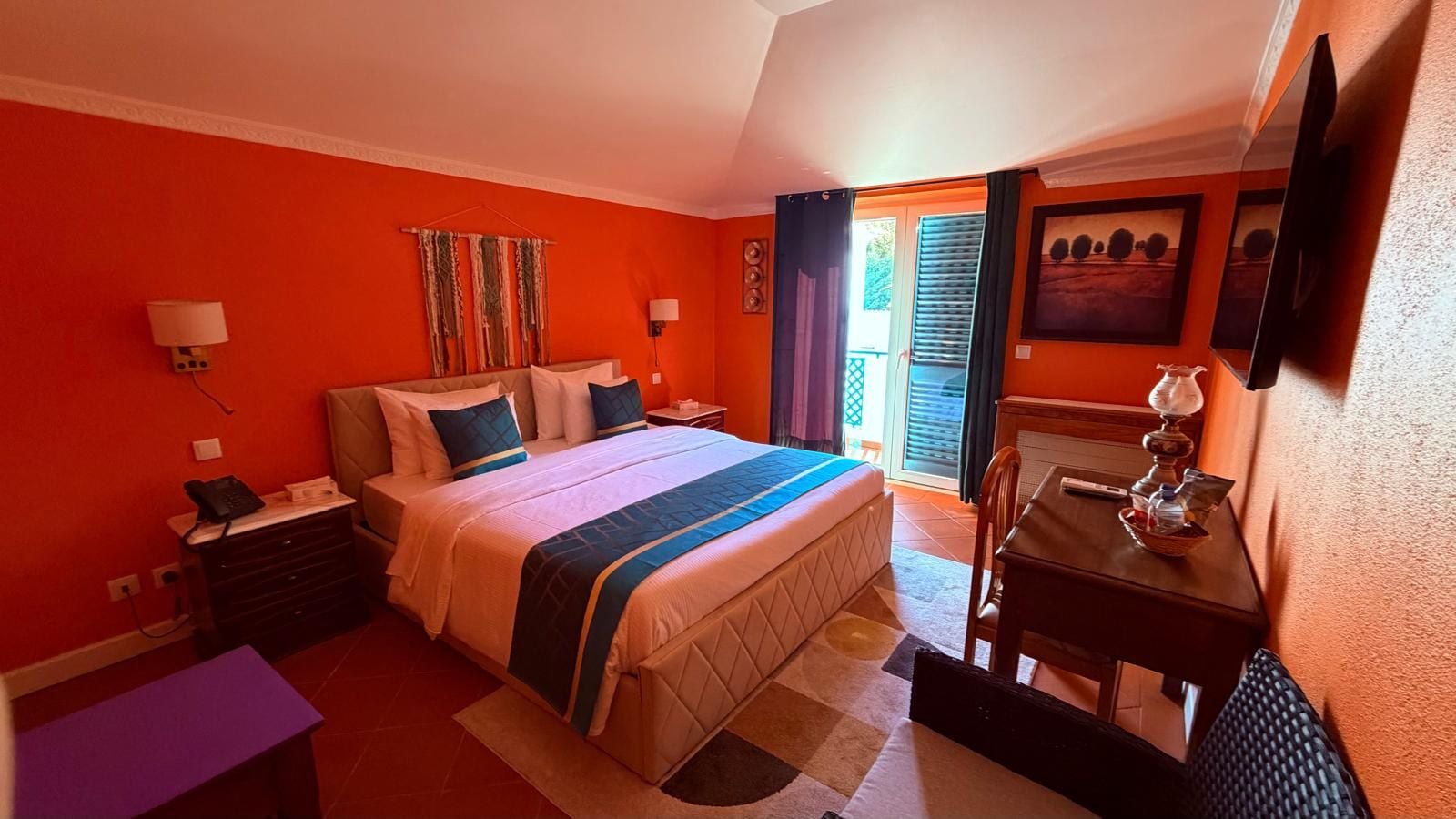 Une chambre d’hôtel avec un lit, des tables de chevet, un bureau et une chaise.