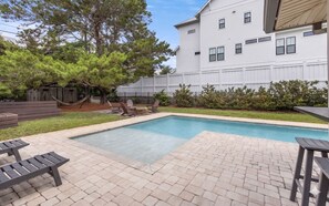 A backyard with a swimming pool, patio furniture, and a wooden deck. - Private Pool - Bikes - Game Room - Steps to Beach (Santa Rosa Beach)