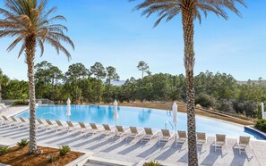 A pool area with lounge chairs and palm trees.