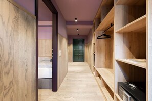 A hallway with wooden walls and a green door at the end.