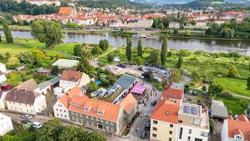 A riverside town with historic buildings, a river, and a park.