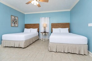 A room with two beds, a ceiling fan, a nightstand, and a wall-mounted light fixture. - Phoenix Ix 1109 2 Bedroom Condo (Orange Beach)