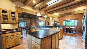 Una cocina amplia con vigas de madera, una isla grande y un comedor con vistas.