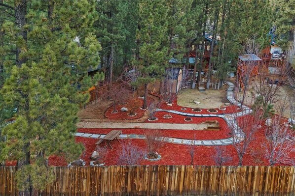 A residential area with a central gazebo surrounded by a red landscaped garden.
