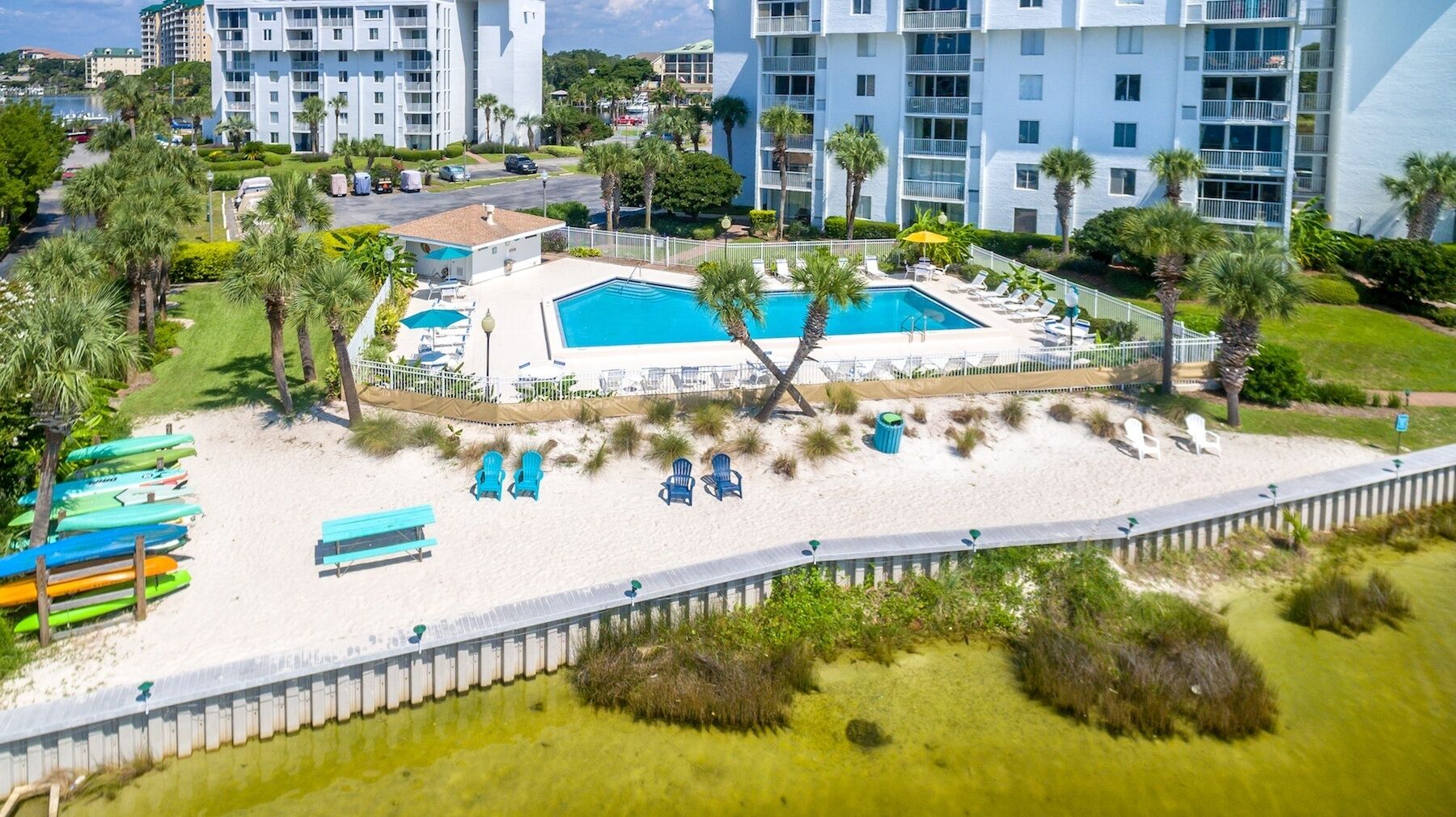 Un complexe hôtelier doté d’une piscine, de chaises de plage et d’un poste de surveillance pour les sauveteurs.