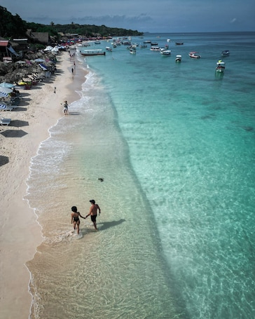 En la playa, arena blanca, traslado desde/hacia la playa, camas de playa