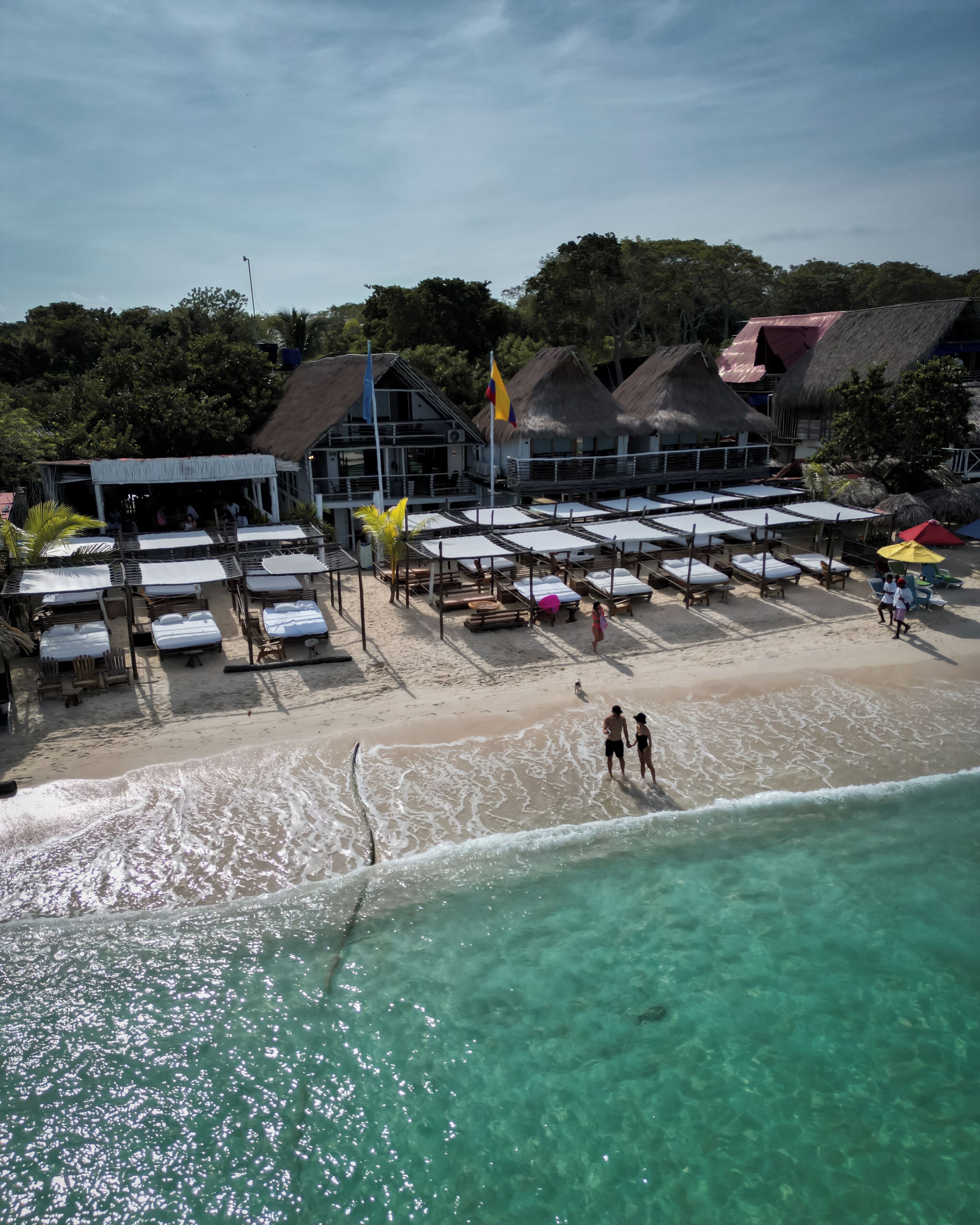 På stranden, hvit sand, strandbuss og strandtelt (mot et tillegg)