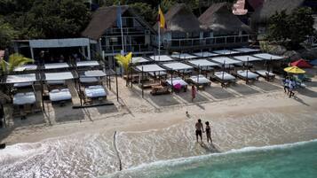 På stranden, hvit sand, strandbuss og strandtelt (mot et tillegg)