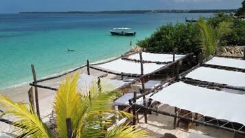 På stranden, hvit sand, strandbuss og strandtelt (mot et tillegg)