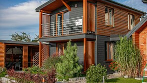 A two-story house with a balcony, a sign indicating a sauna, and a well-maintained garden. - Holiday Studio With Balcony, Gaski (Mielno)