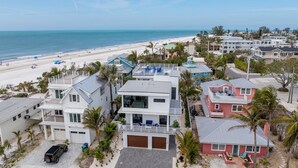 A coastal residential area with modern houses, a beach, and a clear view of the ocean. - Bleuphoria! Rooftop Views and Poolside Fun! (Anna Maria)