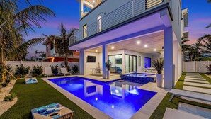 A modern house with a swimming pool, outdoor seating, and a covered patio area. - Bleuphoria! Rooftop Views and Poolside Fun! (Anna Maria)