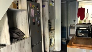Eine kleine Küche mit Waschmaschine, Mikrowelle und Toaster.