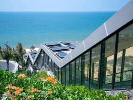 A modern building with large windows overlooking the ocean.