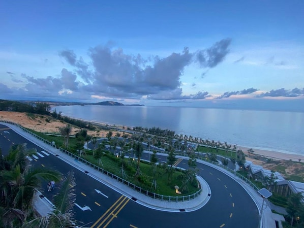 A coastal road with a roundabout, beach, and ocean view.