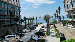 Ein Parkplatz mit Autos, Palmen und modernen Gebäuden mit großen Fenstern.