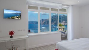 A bedroom with a large window offering a view of the sea and mountains. - Il Corallo Praiano (Praiano)