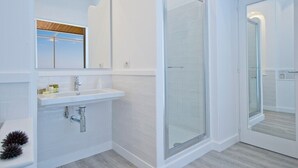 A modern bathroom with a glass shower enclosure, a white sink, and a large mirror. - Il Corallo Praiano (Praiano)
