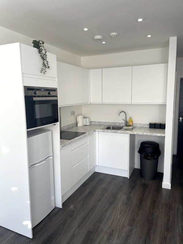 Refrigerador, microondas, utensilios de cocina, mesa de comedor
