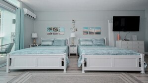 Habitación doble con televisión, obras de arte y ventana.