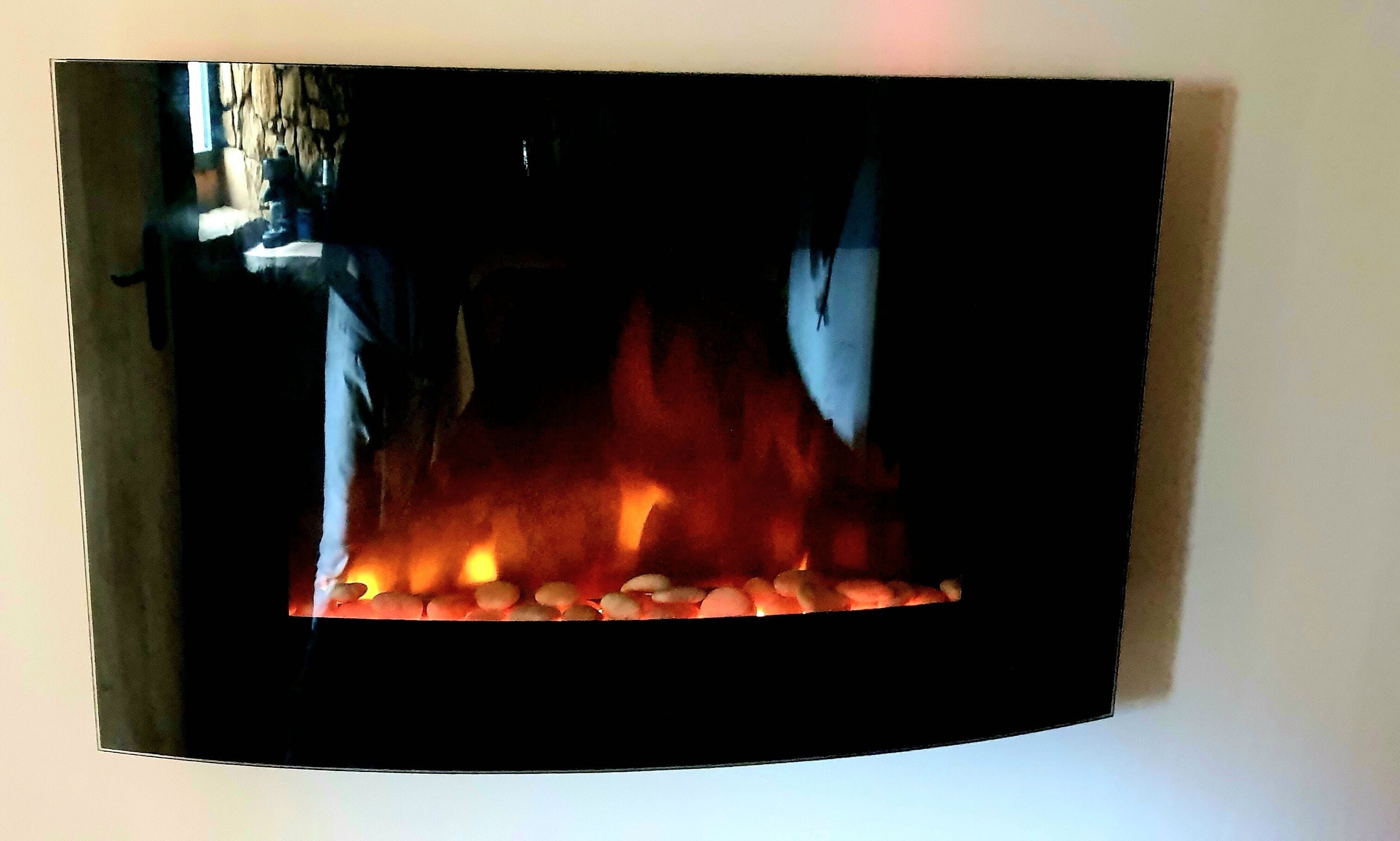 Une cheminée avec des bûches et des flammes apparentes.