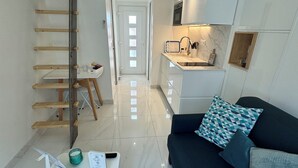 A modern living room with a sofa, a coffee table, and a wooden ladder against the wall. - Almar Studio -Albufeira- 2 min. walk from the beach and center - 2/3 people (Albufeira)