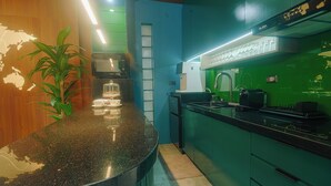 A modern kitchen with a black granite countertop, green cabinets, and a stainless steel range hood. - Executive 2-bedroom condo in Subic Bay Freeport Zone (Subic Bay Freeport Zone)