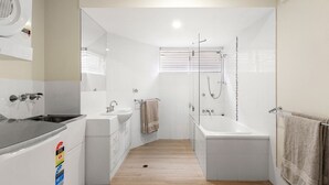 Et moderne badeværelse med bruser, vask og toilet.