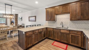 A modern kitchen with wooden cabinets, a granite countertop, and a built-in oven.