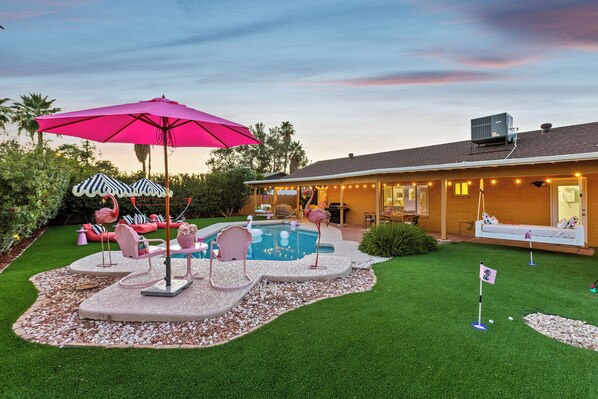 Un jardin avec une piscine, du mobilier d’extérieur et un espace patio.