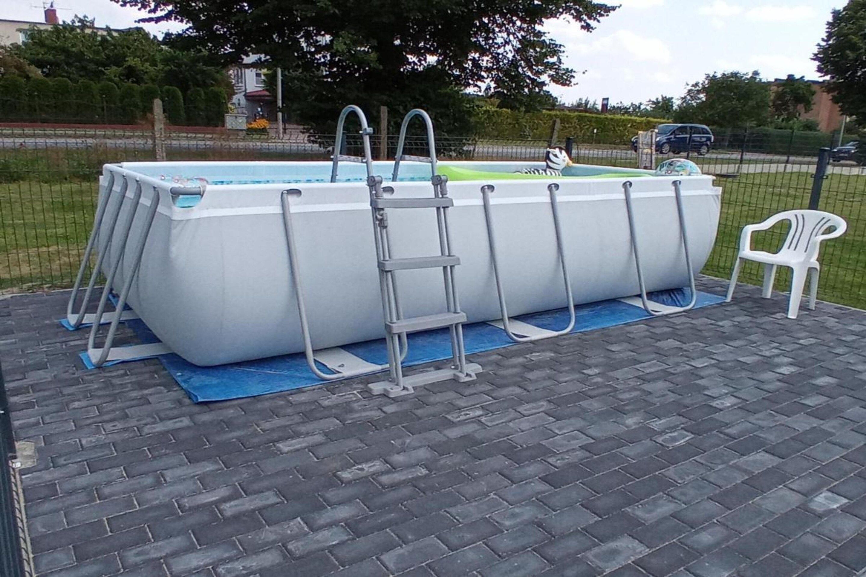 Une piscine hors sol, équipée d’une échelle et d’une chaise.