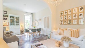 Un amplio salón con un sofá blanco, una mesa de centro y un comedor con sillas y una mesa.