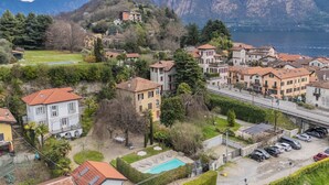 Zona residencial con casas, piscina y vistas a montañas y un lago.