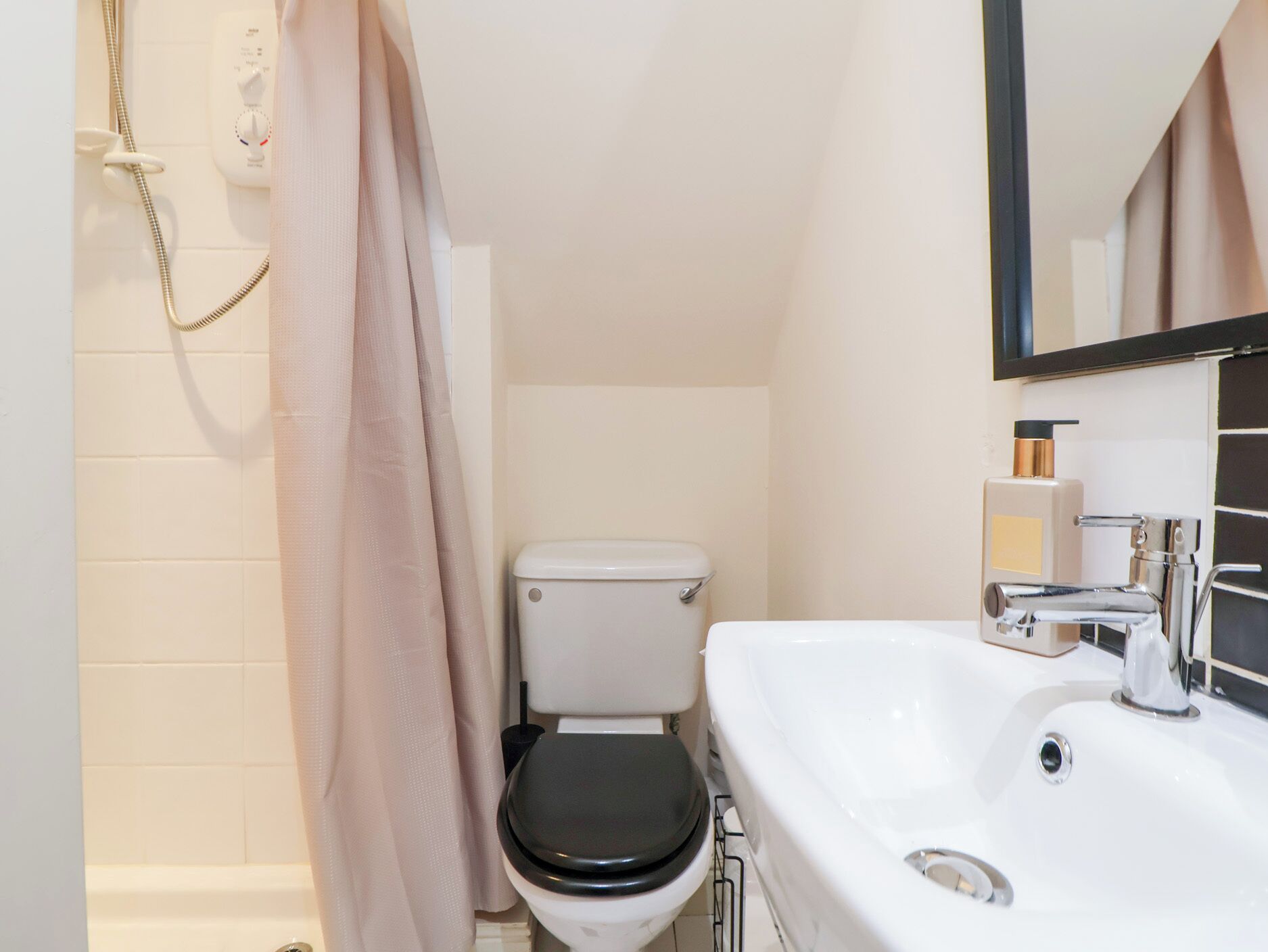 A bathroom with a toilet, a sink, and a shower.