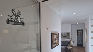 A room with a dining table, chairs, and a painting on the wall.