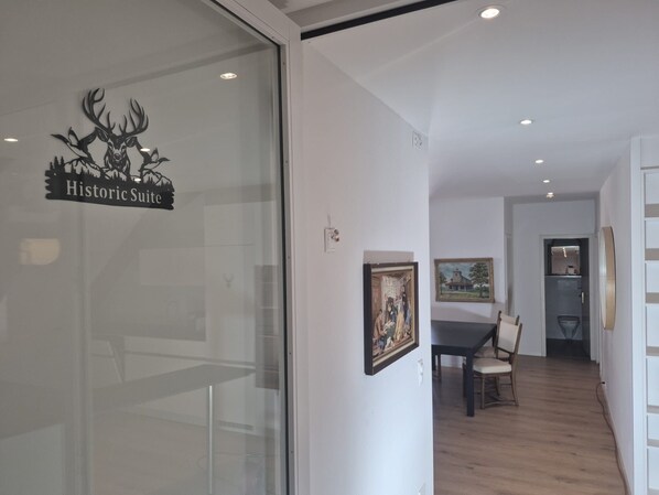 A room with a dining table, chairs, and a painting on the wall.