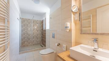A modern bathroom with a shower, toilet, and sink.