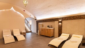 A spa area with two massage tables, a wooden cabinet, and a staircase. - Oázis Hotel Apartments (Nagykanizsa)