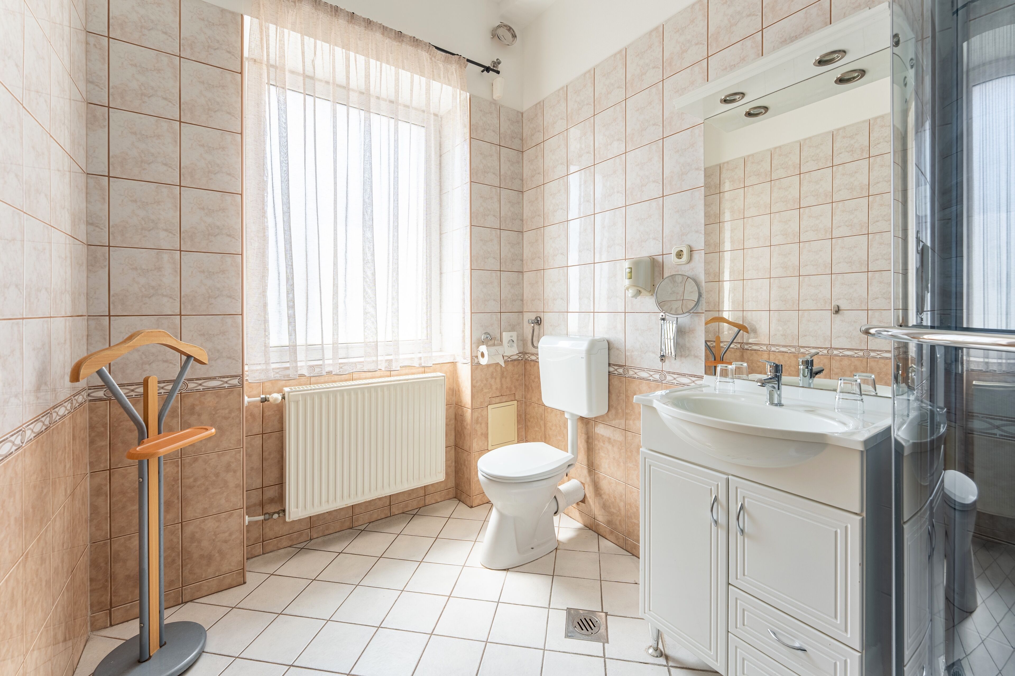 Un baño con inodoro, lavamanos y zona de ducha.