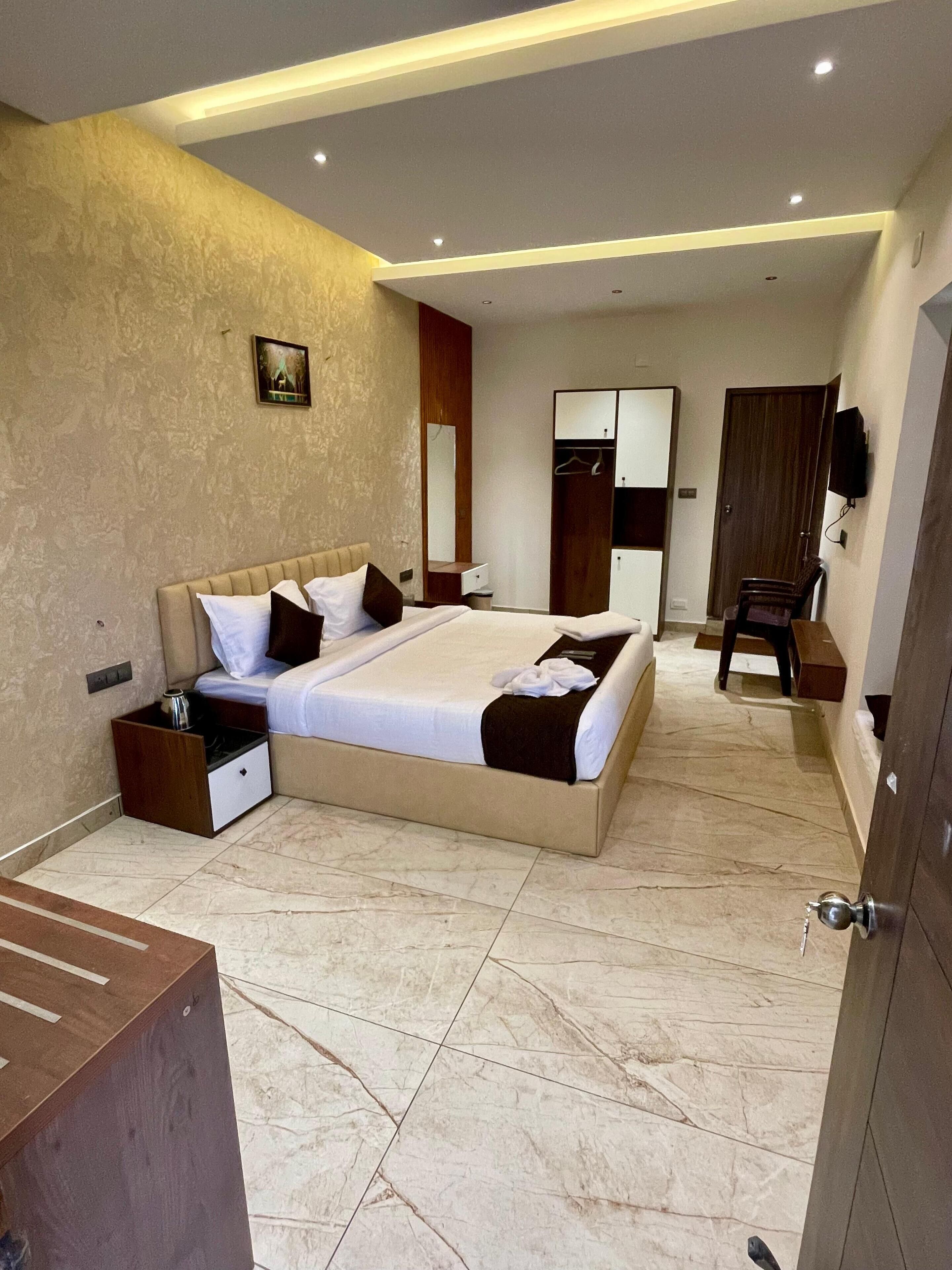 A modern bedroom with a large bed, a wardrobe, a bedside table, and a mirror.