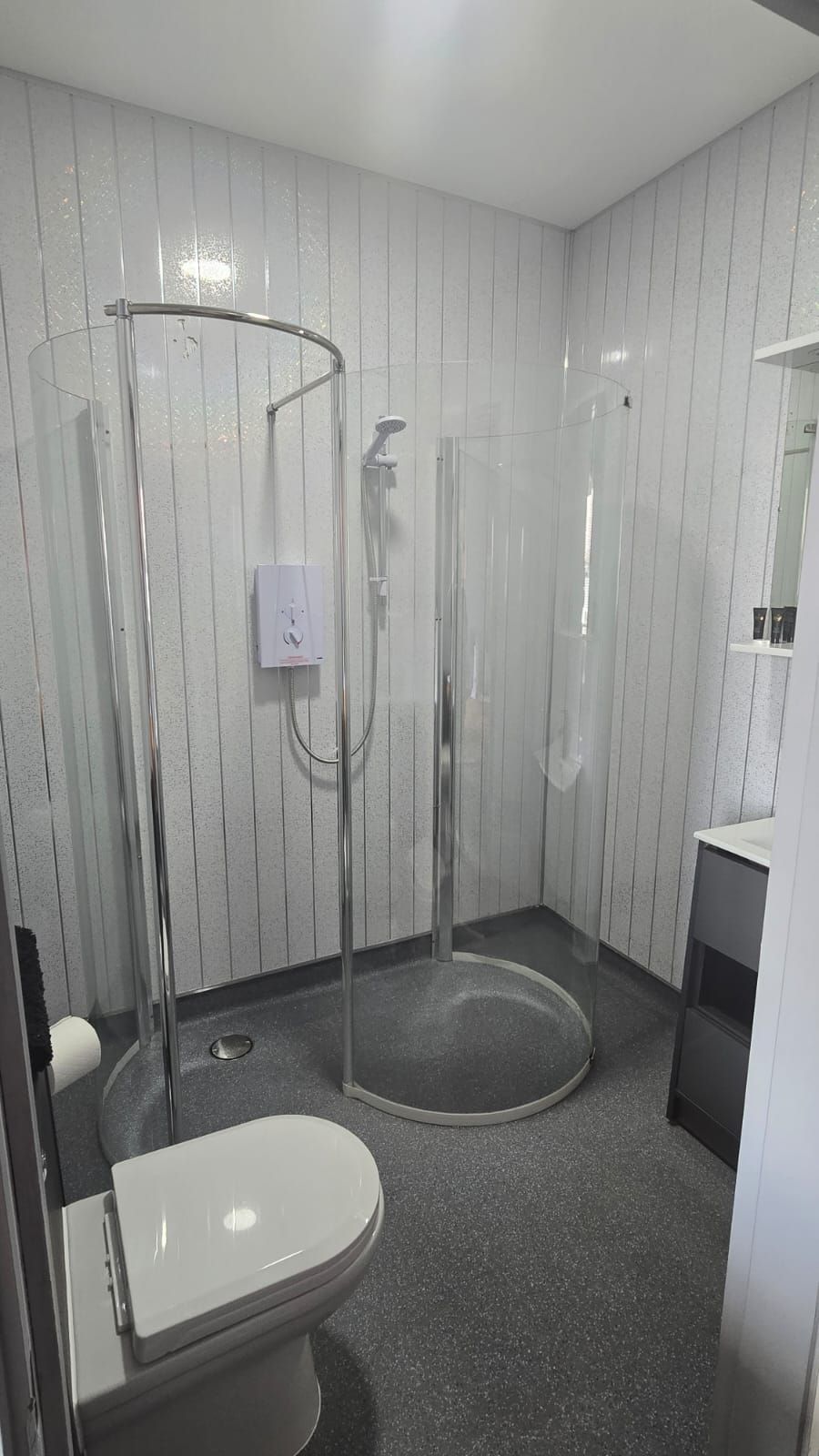 Une salle de bain comprenant des toilettes, un espace douche et un lavabo.