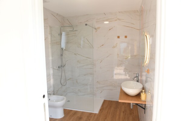 A modern bathroom with a glass-enclosed shower, a white sink, and a toilet. - Vizinhos do Sol Turismo Rural (Sao Pedro do Sul)